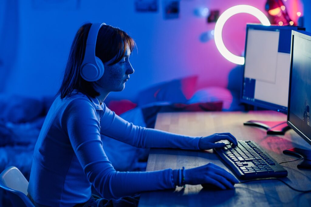 Teenage girl playing video game on computer