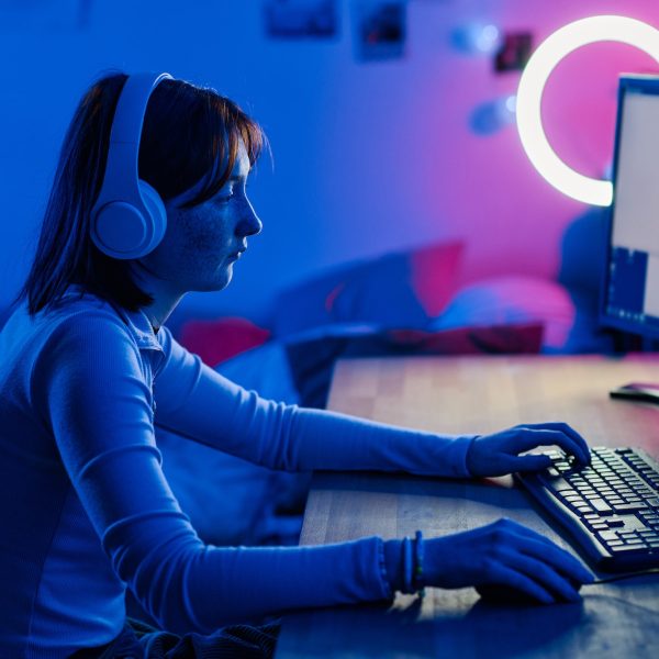 Teenage girl playing video game on computer